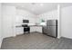 Modern kitchen with stainless steel appliances, white cabinetry, and beautiful wood-look flooring at 13438 Leaping Water Way, Astatula, FL 34705
