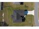Aerial view of a home featuring a dark roof, driveway, landscaping, and surrounding green lawn space at 2840 Sw 166 Th Ln, Ocala, FL 34473