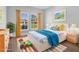 Staged bedroom with a bed, colorful accents, two windows, and colorful rug at 2840 Sw 166 Th Ln, Ocala, FL 34473
