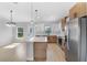 Contemporary kitchen with white and wood cabinets, stainless steel appliances, and an island, seamlessly connected to living space at 2840 Sw 166 Th Ln, Ocala, FL 34473