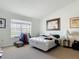 Modest bedroom with large window, framed art, clothing rack and carpet floors at 3926 Grassland Dr, Orlando, FL 32824