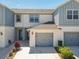 Charming two-story townhome featuring a gray two-car garage, stylish gray and white paint, and a well-maintained lawn at 3926 Grassland Dr, Orlando, FL 32824