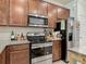 Kitchen area featuring stainless steel appliances, granite countertops and dark wood cabinets at 3926 Grassland Dr, Orlando, FL 32824