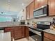 Kitchen showcasing stainless steel appliances, granite countertops, wood cabinets, and wood-look floors at 3926 Grassland Dr, Orlando, FL 32824