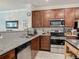Kitchen area featuring stainless steel appliances, granite countertops and dark wood cabinets at 3926 Grassland Dr, Orlando, FL 32824