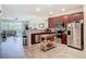 Open kitchen featuring stainless steel appliances, granite countertops, dark wood cabinets, and wood-look floors at 3926 Grassland Dr, Orlando, FL 32824