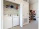 Functional laundry room with washer, dryer, storage, and shelving at 3926 Grassland Dr, Orlando, FL 32824