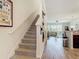 Open-concept space with a staircase, wood-look floors, and a view into the living room with a sliding glass door at 3926 Grassland Dr, Orlando, FL 32824