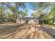 House backyard featuring a sliding glass door surrounded by lush trees at 39832 N Hibiscus Way, Lady Lake, FL 32159