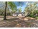 Back of house featuring a sliding glass door and wooded surroundings at 39832 N Hibiscus Way, Lady Lake, FL 32159