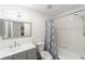 Bathroom features a gray vanity, a shower-tub combination, and a gray-trimmed mirror with an exhaust fan at 39832 N Hibiscus Way, Lady Lake, FL 32159