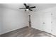 Bedroom boasts a ceiling fan, gray wood-look floors, a neutral color palette, and an ensuite bathroom at 39832 N Hibiscus Way, Lady Lake, FL 32159