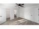 Bedroom boasts a ceiling fan, gray wood-look floors, an ensuite bathroom, and access to a walk-in closet at 39832 N Hibiscus Way, Lady Lake, FL 32159