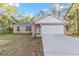 Inviting single-story home with a two-car garage, set on a lush green lot under a sunny sky at 39832 N Hibiscus Way, Lady Lake, FL 32159