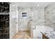 Bathroom featuring a large tub, dark granite accents, and tiled walls at 774 Lobelia Dr, Davenport, FL 33837