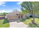 Charming single-story home featuring an attached two-car garage, large tree, and a well-maintained lawn at 774 Lobelia Dr, Davenport, FL 33837