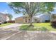Charming single-story home featuring an attached two-car garage, large tree, and a well-maintained lawn at 774 Lobelia Dr, Davenport, FL 33837