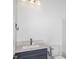 Bathroom with a white sink, a blue cabinet, and a toilet, simple and functional design at 8734 Sw 55Th Street Rd, Ocala, FL 34481