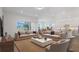 Bright living room features dual sofas, an area rug, and an open floor plan to the kitchen and dining area at 8734 Sw 55Th Street Rd, Ocala, FL 34481