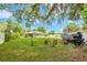 Large backyard with seating area, mature trees, and ample space for recreation and relaxation at 1007 Cr 463B, Lake Panasoffkee, FL 33538