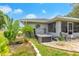 Backyard with a hot tub, a seating area and a screened patio area, surrounded by landscaping at 1007 Cr 463B, Lake Panasoffkee, FL 33538