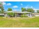 Inviting home with well-kept lawn, landscaping, and a cheerful yellow front door enhances curb appeal at 1007 Cr 463B, Lake Panasoffkee, FL 33538