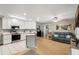 Bright open kitchen with white cabinets, stainless appliances, and view of the living area with blue sofa at 1007 Cr 463B, Lake Panasoffkee, FL 33538