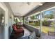 Relaxing screened porch featuring comfortable wicker seating and picturesque garden views at 1007 Cr 463B, Lake Panasoffkee, FL 33538