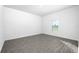 Minimalist bedroom featuring wood-look flooring, a window, and clean white walls at 13284 Tula Loop, Astatula, FL 34705