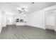 Bright living room featuring wood-look floors, a ceiling fan, and an open layout connecting to the kitchen at 13284 Tula Loop, Astatula, FL 34705