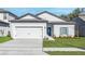 Beautiful single-story home with a two-car garage, blue door, and well-maintained front yard at 13442 Leaping Water Way, Astatula, FL 34705