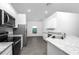 Modern kitchen featuring granite countertops, stainless steel appliances, and sleek gray flooring at 13442 Leaping Water Way, Astatula, FL 34705