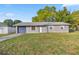 The exterior of a charming single story home with a blue garage door and well maintained lawn at 5728 Ne 21St Avenue Rd, Ocala, FL 34479