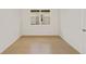Bright, empty room with ceramic tile floor, white walls, base trim, and a large window at 8787 Sw 52Nd Place Rd, Ocala, FL 34481