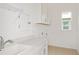 Well-lit laundry room with white cabinetry, a utility sink, and a large window at 8787 Sw 52Nd Place Rd, Ocala, FL 34481