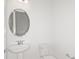 Clean powder room features a modern pedestal sink, oval mirror, and efficient toilet at 8787 Sw 52Nd Place Rd, Ocala, FL 34481