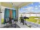 This cozy patio has outdoor seating, stylish curtains, string lights, and a grill for entertaining guests in style at 879 Killarney Ln, Auburndale, FL 33823