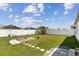 The fenced backyard includes a hammock, mature banana plants, and a stone-paved area, creating a relaxing retreat at 879 Killarney Ln, Auburndale, FL 33823