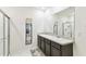 Bright bathroom with double vanity sinks, shower, and full-length mirror at 879 Killarney Ln, Auburndale, FL 33823