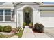 Close-up of the front door with decorative wreath and potted plants, framed by a stucco archway at 879 Killarney Ln, Auburndale, FL 33823