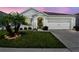 Charming single-story home with well-maintained lawn, landscaping, and an attached two-car garage at dusk at 879 Killarney Ln, Auburndale, FL 33823