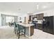 Kitchen includes island with bar seating, black appliances, and dark cabinets at 879 Killarney Ln, Auburndale, FL 33823
