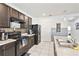 Modern kitchen featuring dark cabinetry, stainless appliances, white tile floors, and ample counter space at 879 Killarney Ln, Auburndale, FL 33823