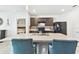 Kitchen features kitchen island with bar stool seating, dark cabinets, and modern appliances at 879 Killarney Ln, Auburndale, FL 33823