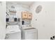 Bright laundry room features white wood-look wall, shelving, and front load washer and dryer at 879 Killarney Ln, Auburndale, FL 33823