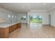 Open-concept living area with a kitchen island and sliding glass doors leading to the outdoors at 8980 Sw 52Nd Place Rd, Ocala, FL 34481