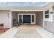 Covered front entrance with double front door, two chairs, and well kept flower bed and manicured lawn at 4523 Oakglen Rd, Lakeland, FL 33813