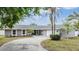 Charming single-story home featuring a circular driveway, attached garage, and well-maintained landscaping with palm trees at 4523 Oakglen Rd, Lakeland, FL 33813