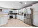 Bright kitchen features white cabinets, stainless steel appliances, granite countertops, and a stylish backsplash at 4523 Oakglen Rd, Lakeland, FL 33813