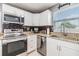 Updated kitchen featuring stainless appliances, granite counters, and a stylish dark backsplash at 4523 Oakglen Rd, Lakeland, FL 33813